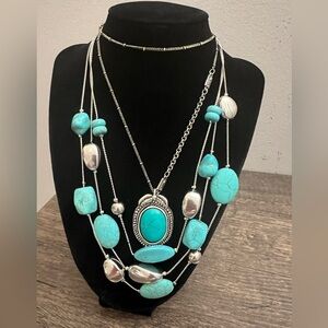 2 turquoise colored and silver necklaces, one multi strand and other w/pendant
